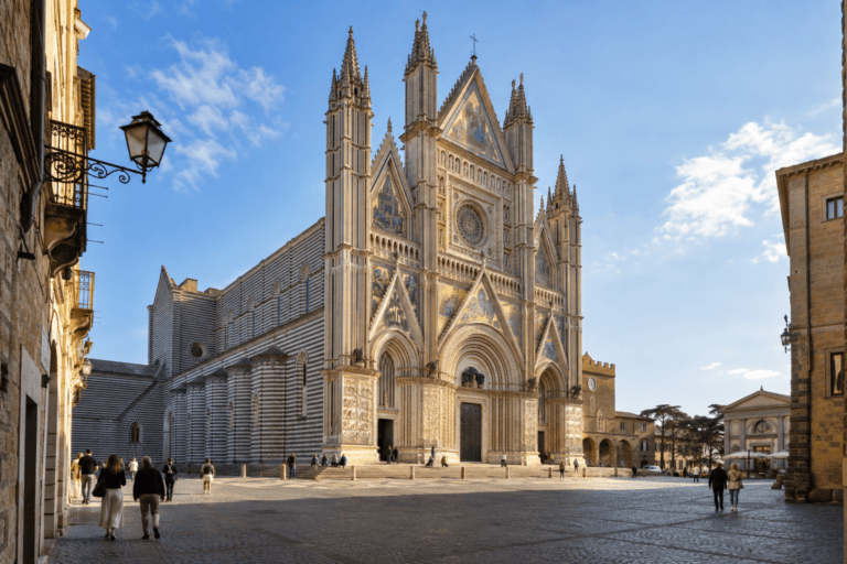 Photorealistic morning view of Orvieto Cathedral and its mosaic façade from Piazza del Duomo with pedestrians crossing the square