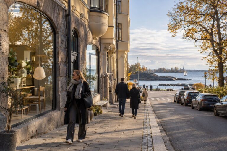 Pedestrians beside Jugend buildings and the Baltic waterfront in Helsinki’s Eira district in autumn