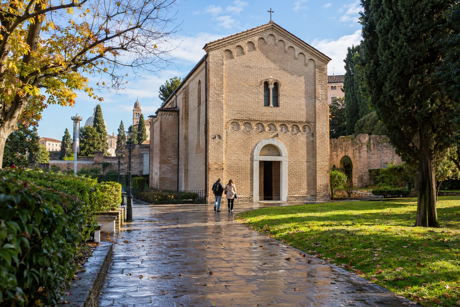 Visitors approaching the brick Scrovegni Chapel in Padua after morning rain