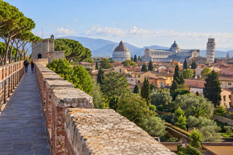 Camminamento sulle mura medievali affacciato sui tetti, i giardini e Piazza del Duomo di Pisa al mattino