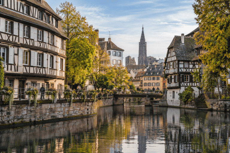 Photorealistic autumn view of Petite France in Strasbourg with half-timbered houses, the River Ill and the cathedral spire